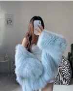 Light blue Thick Fluffy Faux Fur Coat draped over a phone.