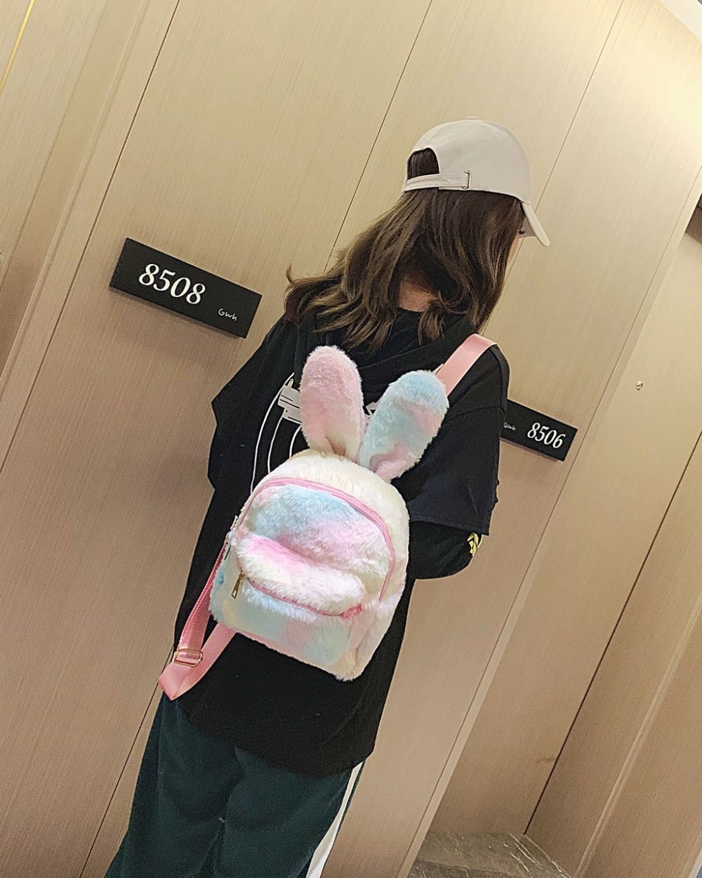 A pink Rabbit Ears Plush Backpack worn by a person.