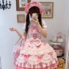 A young woman wearing a pink Hime Lolita Dress, with lace details and ribbons, posing for a selfie.