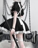 Black and white Kawaii Maid Dress with a frilly apron, sword, and accessories.