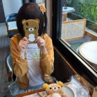 Person wearing a Jojifuku Hoodie at a cafe, featuring a bear graphic.