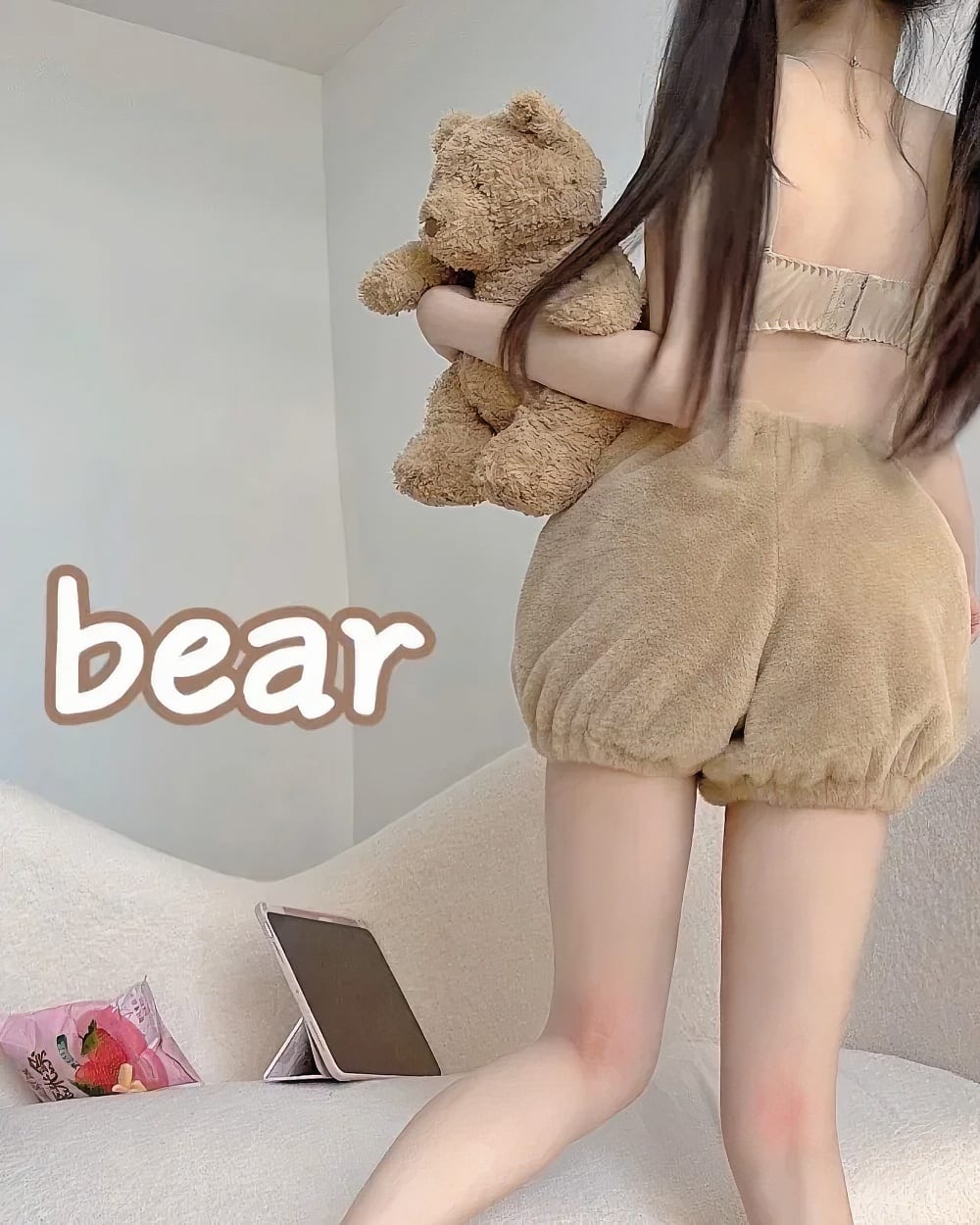 Person wearing Soft Plush Bear Pajamas with a teddy bear.