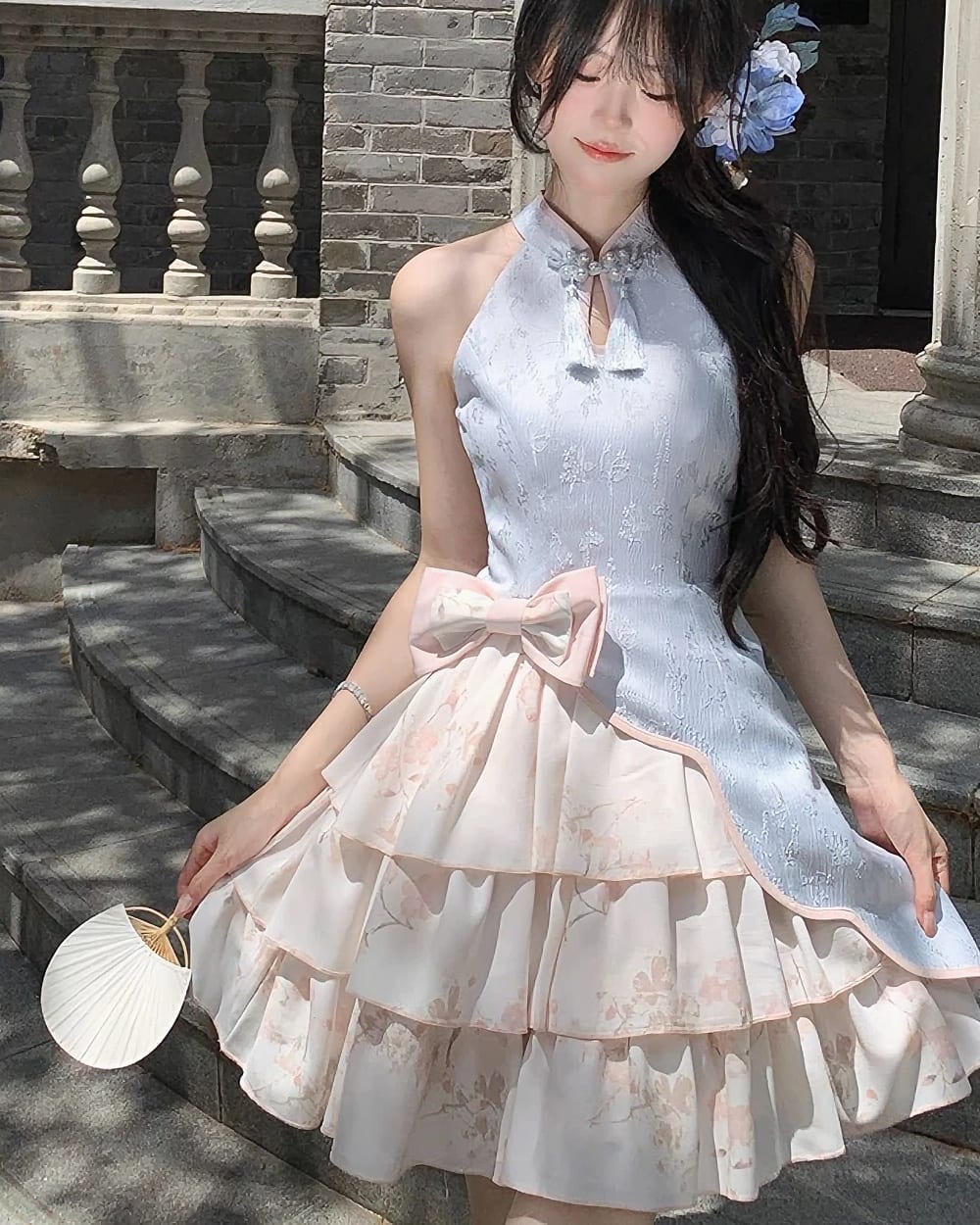 A light blue Qi Lolita Dress with floral print and layers, featuring a bow detail.