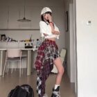 Patched plaid Grunge Aesthetic Skirt worn with a white top and boots.