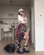Patched plaid Grunge Aesthetic Skirt worn with a white top and boots.