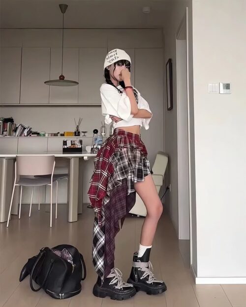 Patched plaid Grunge Aesthetic Skirt worn with a white top and boots.