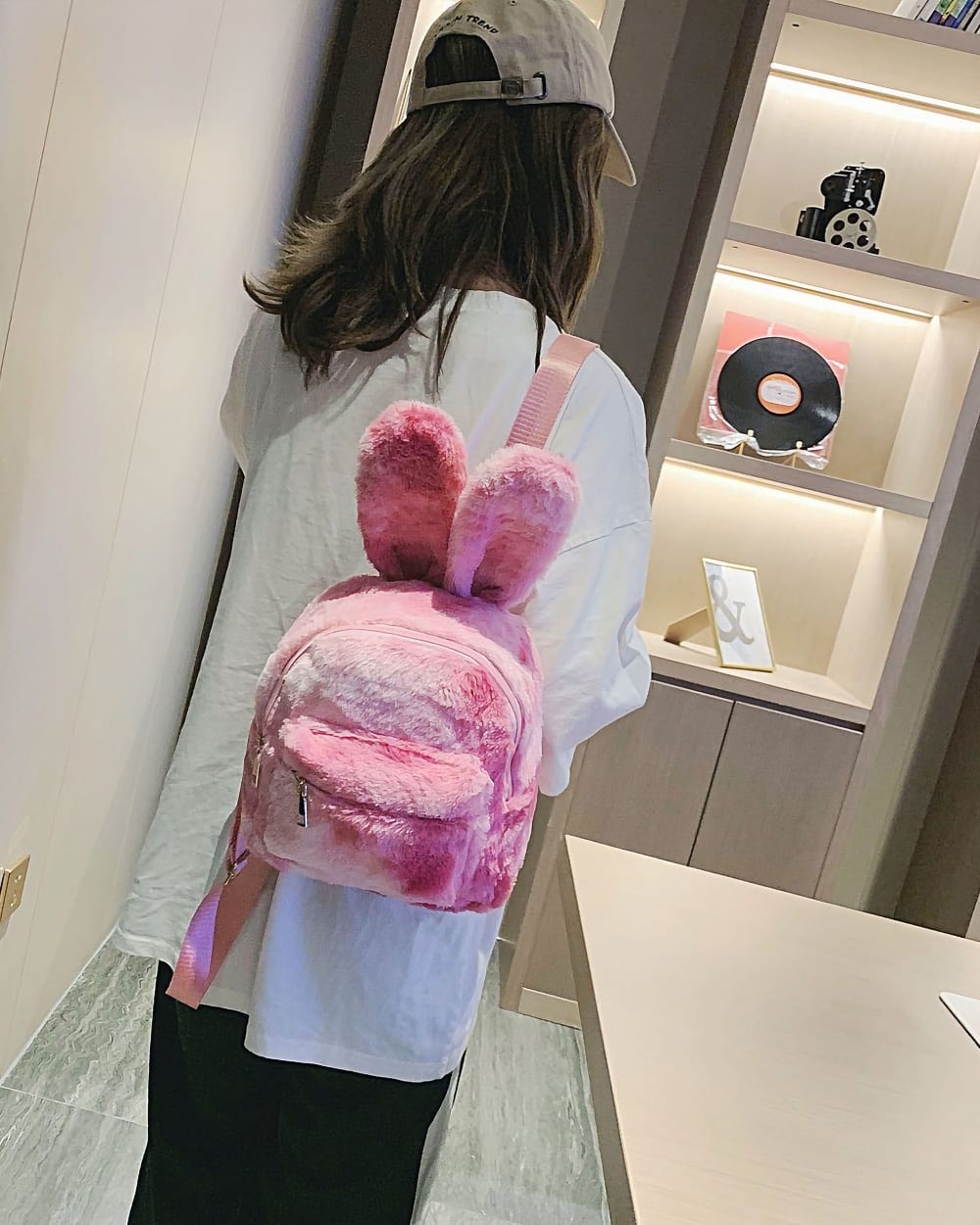 Pink Rabbit Ears Plush Backpack shown carried by a person.
