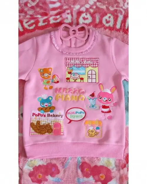 Pink Mezzo Piano Sweatshirt featuring cute characters and bakery/town designs.