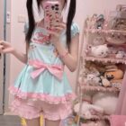 A person wearing a Cute Lolita Pastel Top - Jojifuku Aesthetic, featuring a pale blue dress with floral print and ribbons.