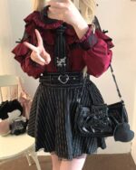 Woman wearing a Long Sleeve Blouse – Jirai Kei Aesthetic, featuring ruffles and lace details, styled with a striped skirt and accessories.