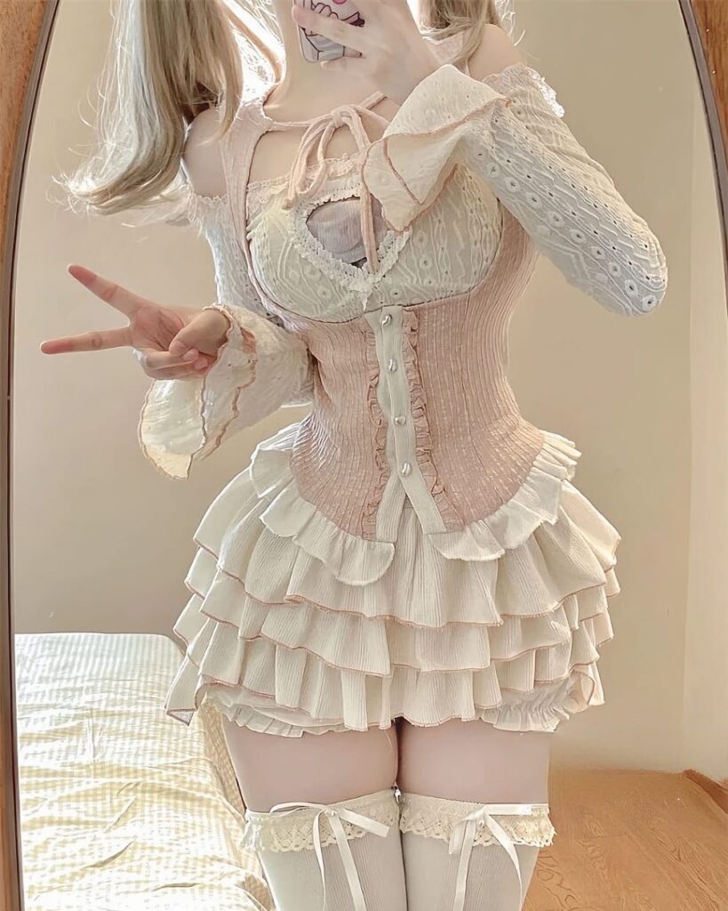 Ruffled pink Dollette Aesthetic Dress set with corset and layered skirt. Lace details and long sleeves.
