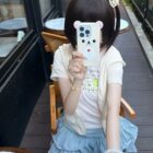 Person wearing a Kuma Zip Up Hoodie - Jojifuku Hoodie, holding a phone.