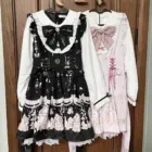 Three Jirai Kei Dresses in black, pink, and white, hung on a hanger.