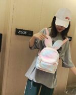 Pink Rabbit Ears Plush Backpack being held, featuring a zipper closure and shoulder straps.