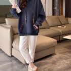 Blue Ethno-Chic Hoodie worn by a woman, paired with white pants and sneakers.