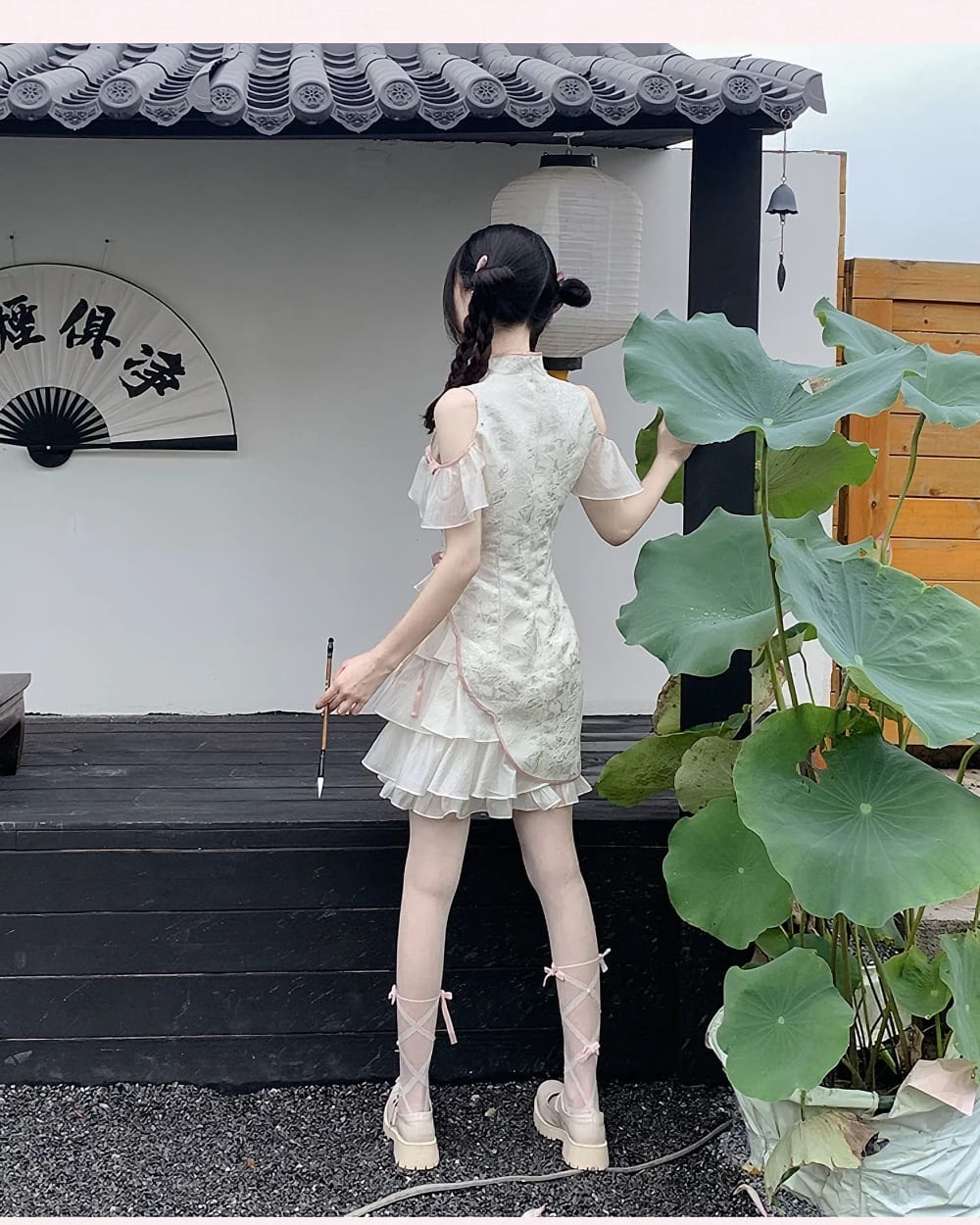 A person wearing a Qi Lolita Dress, a cheongsam-style cute dress with ruffled details and off-the-shoulder sleeves.