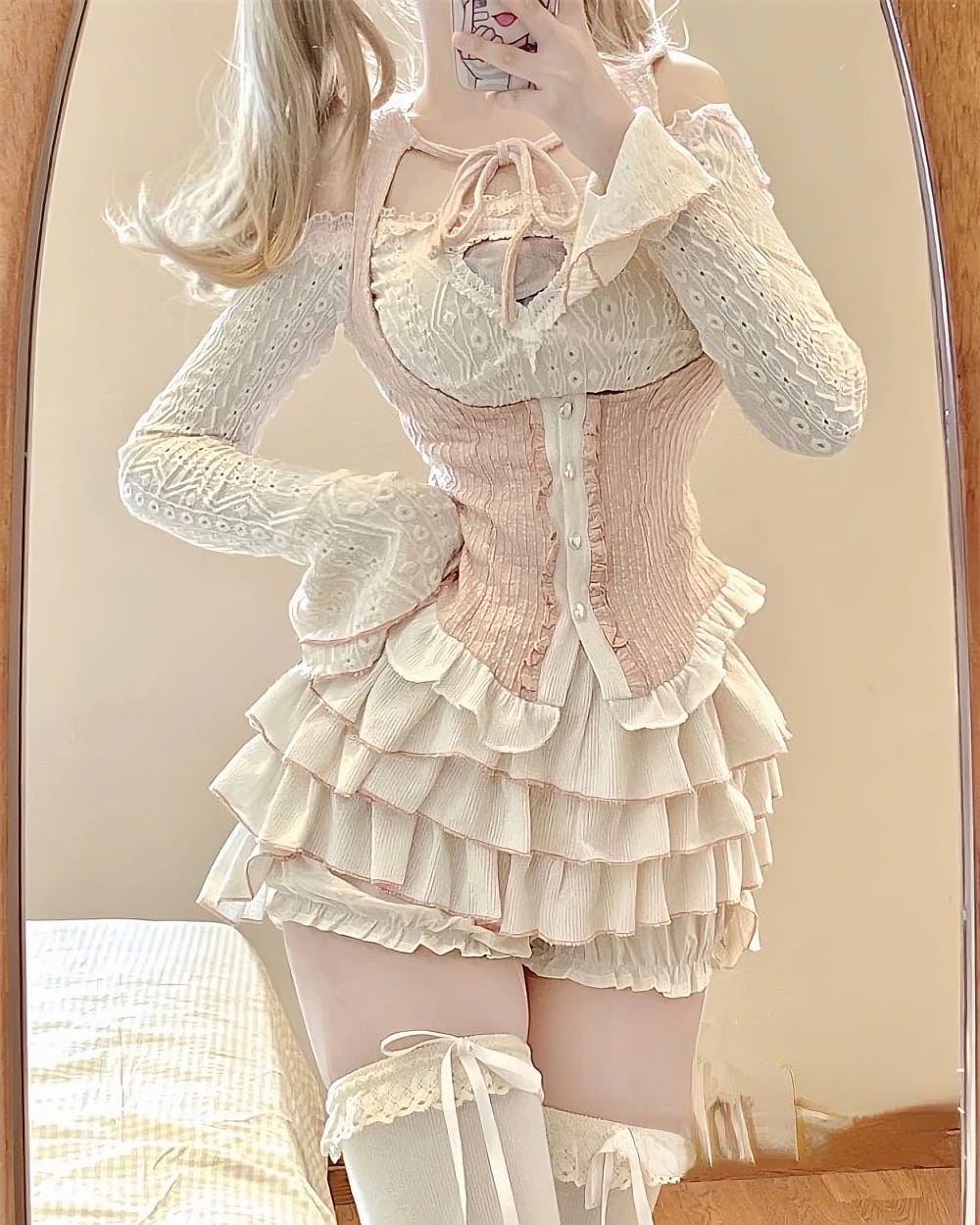 Ruffled pink dress set, Dollette Aesthetic, featuring a corset and layered skirt with long sleeves and thigh-high socks.