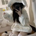 Person wearing a white Bear Paw Hoodie with a hood and attached paw sleeves.