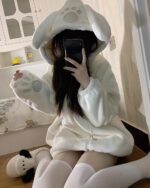 Person wearing a white Bear Paw Hoodie with a hood and attached paw sleeves.