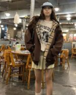 Model wearing a brown Preppy Aesthetic Hoodie with a plaid lining and graphic print.