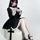 Woman wearing a black Gothic Nun Dress with white lace details, featuring a cross accessory.