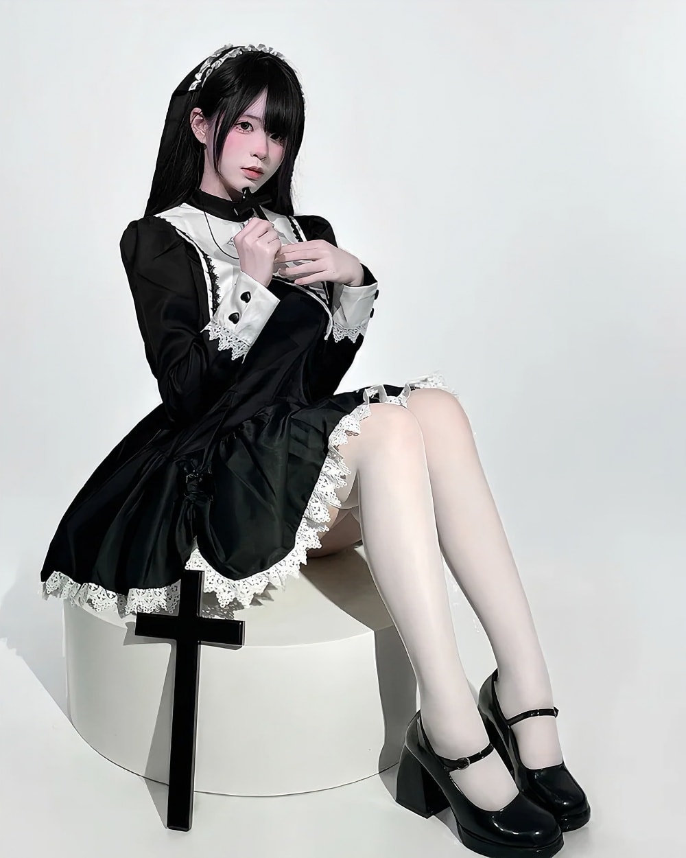 Black Nun Dress - Gothic Aesthetic product photo 1 Woman wearing a black Gothic Nun Dress with white lace details, featuring a cross accessory.