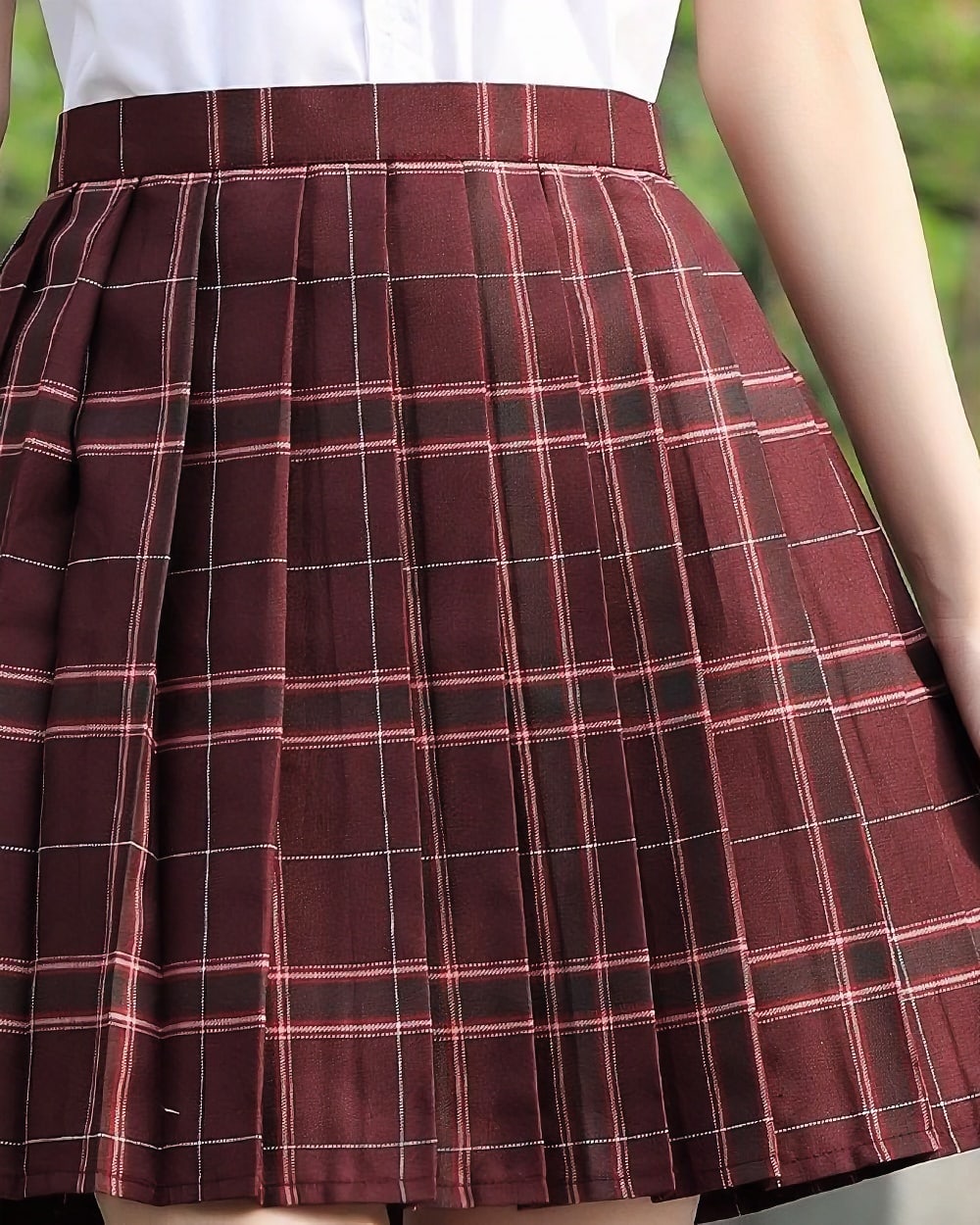 Close-up of a maroon JK Plaid Skirt with white checks, featuring a pleated design.