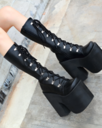 Black lace-up goth platform boots with a thick block heel. High-top design, shown on a model's legs.