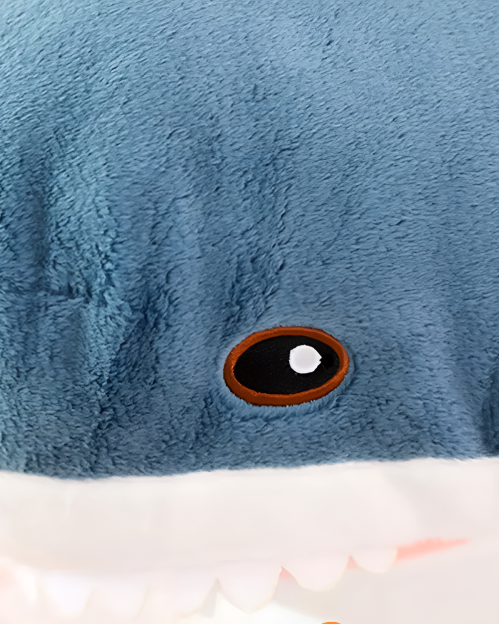 Close-up of Alfred the Shark plushie, featuring a dark eye and white teeth.