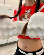 Close-up of a white angel wing backpack attached to a person's hair.