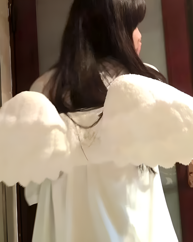 White angel wing backpack displayed on a person's back.