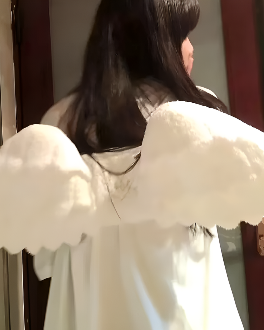 White angel wing backpack shown on a person's back.
