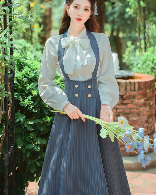Woman wearing an Archive Pinstripe Pinafore Set with an academia aesthetic, featuring a white blouse and pinstripe pinafore.