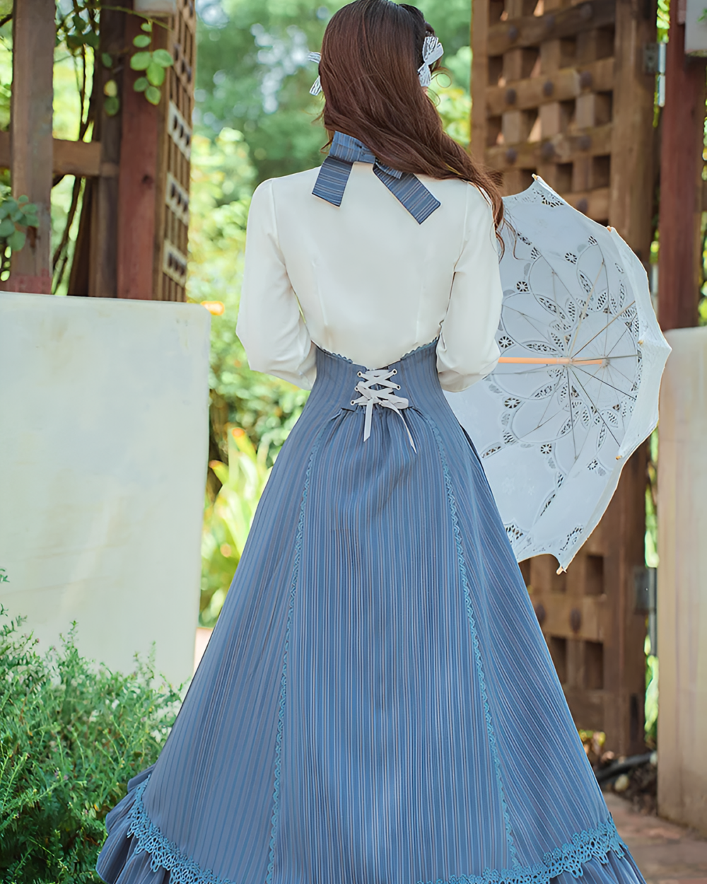 Woman wearing Archive Pinstripe Pinafore Set with an academia aesthetic, featuring a long skirt and white blouse.