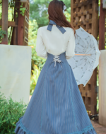 Woman wearing Archive Pinstripe Pinafore Set with an academia aesthetic, featuring a long skirt and white blouse.