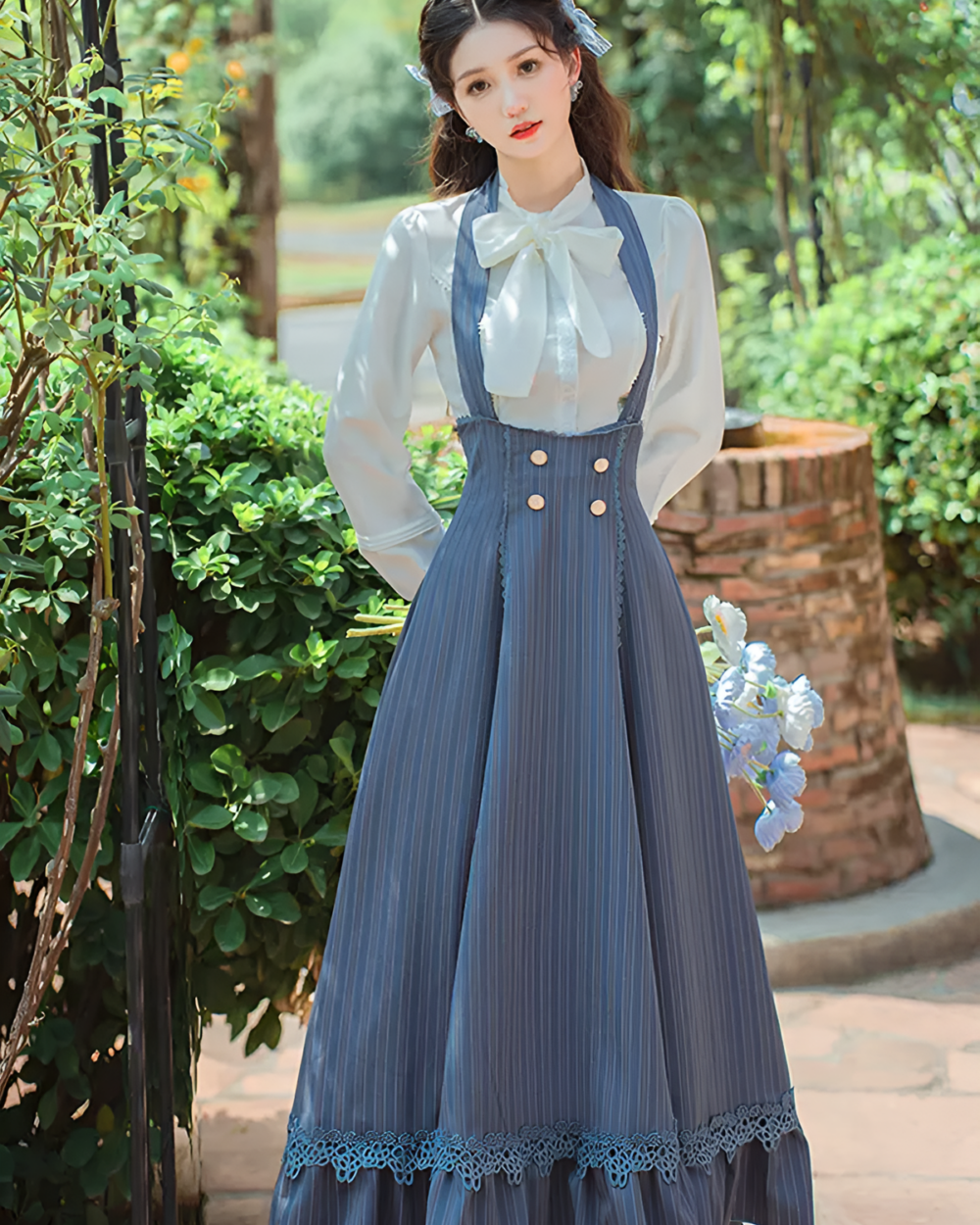 Woman wearing an Archive Pinstripe Pinafore Set, showcasing an academia aesthetic with a white blouse and blue pinstripe pinafore.
