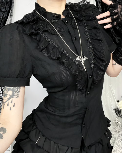Black ruffled blouse with gothic aesthetic details, featuring lace trim and a high neck.