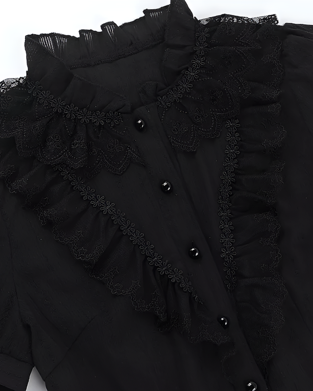 Close-up of a black ruffled blouse featuring gothic aesthetic embroidery and buttons.
