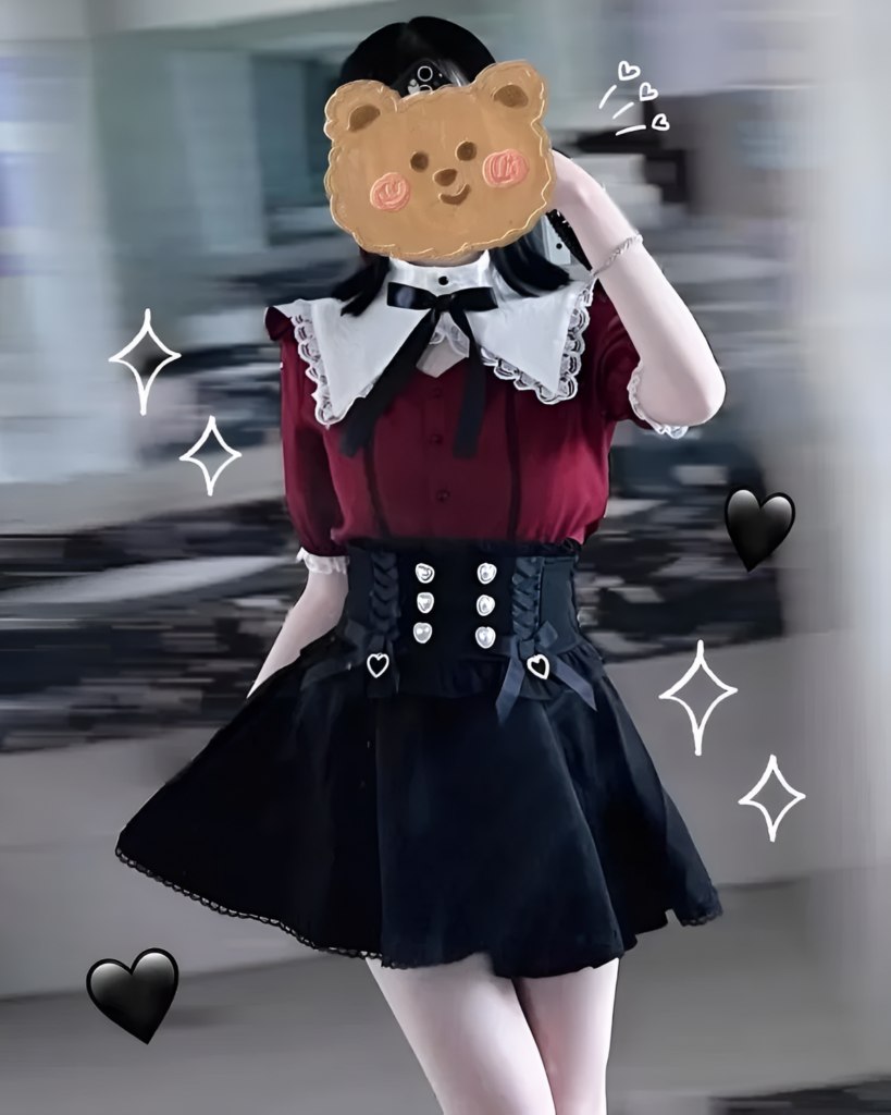 Woman wearing the Bloodmoon Corset Coord, showcasing a Jirai Kei aesthetic with a red top, black skirt & corset.