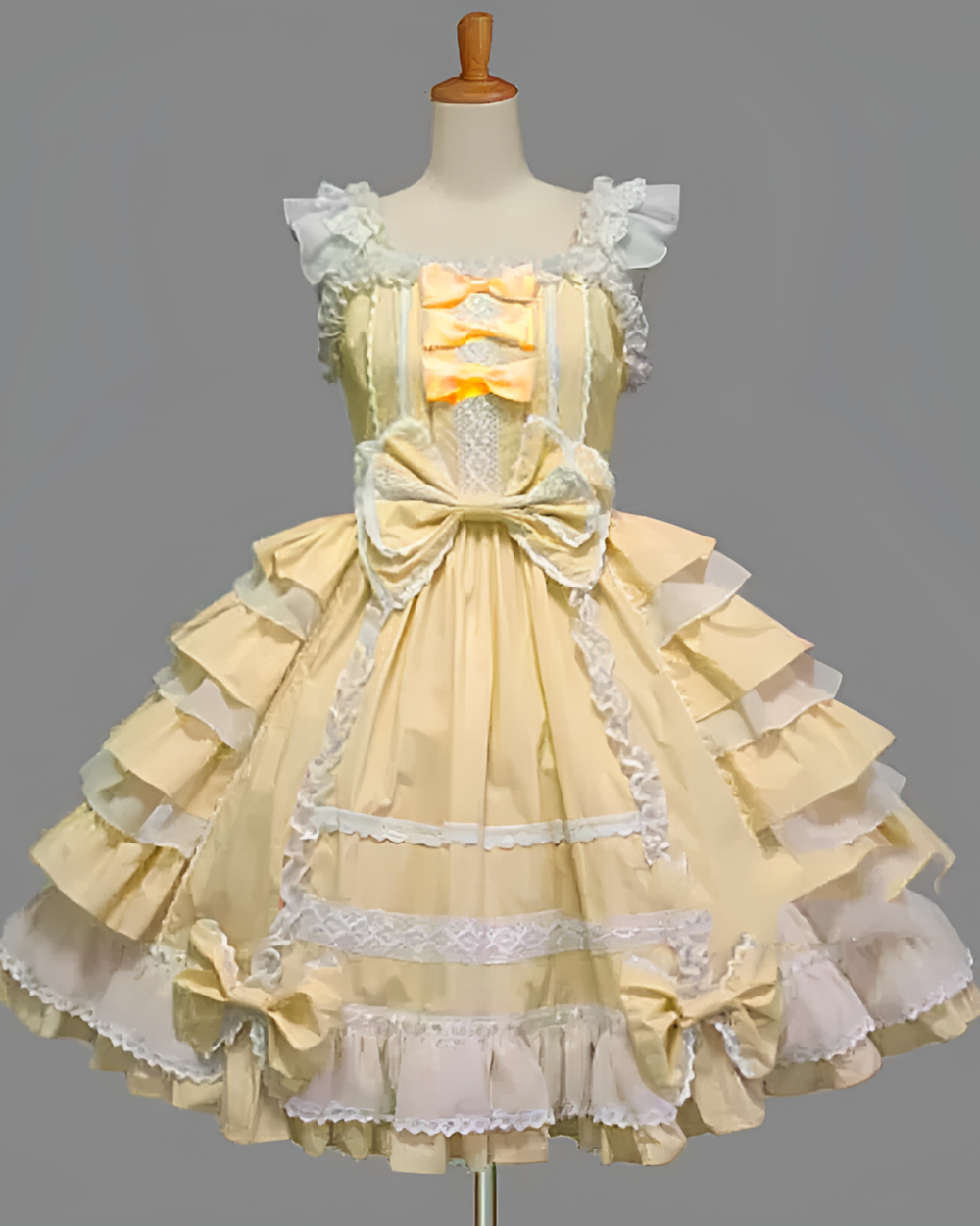 Cream and white Hime Lolita dress with ruffles and lace details, displayed on a mannequin. Features a bow at the bust.