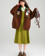 A brown corduroy jacket with patches and pockets, styled with a green dress.