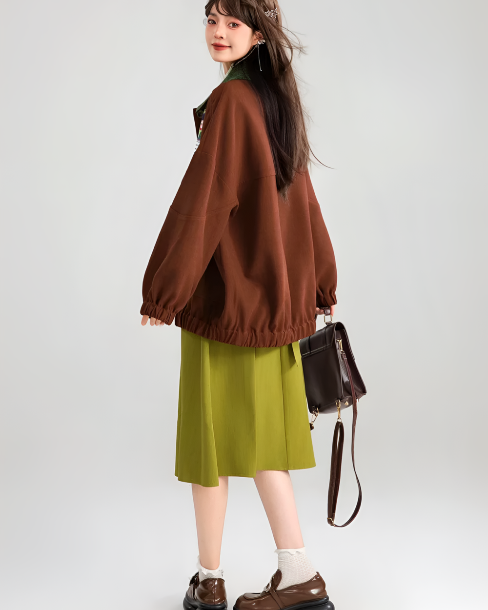 Brown corduroy jacket worn by a young woman with a green dress.