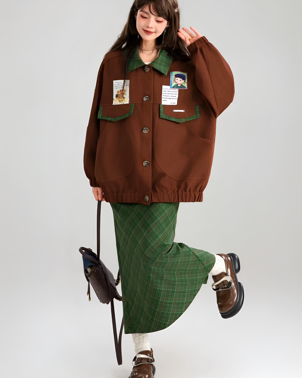 Model wearing a brown corduroy jacket with patches and a green plaid skirt.