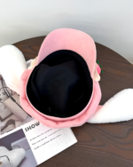 Close-up of a pink strawberry bunny cap, featuring plush details and an interior lining. It is a strawberry bunny cap.