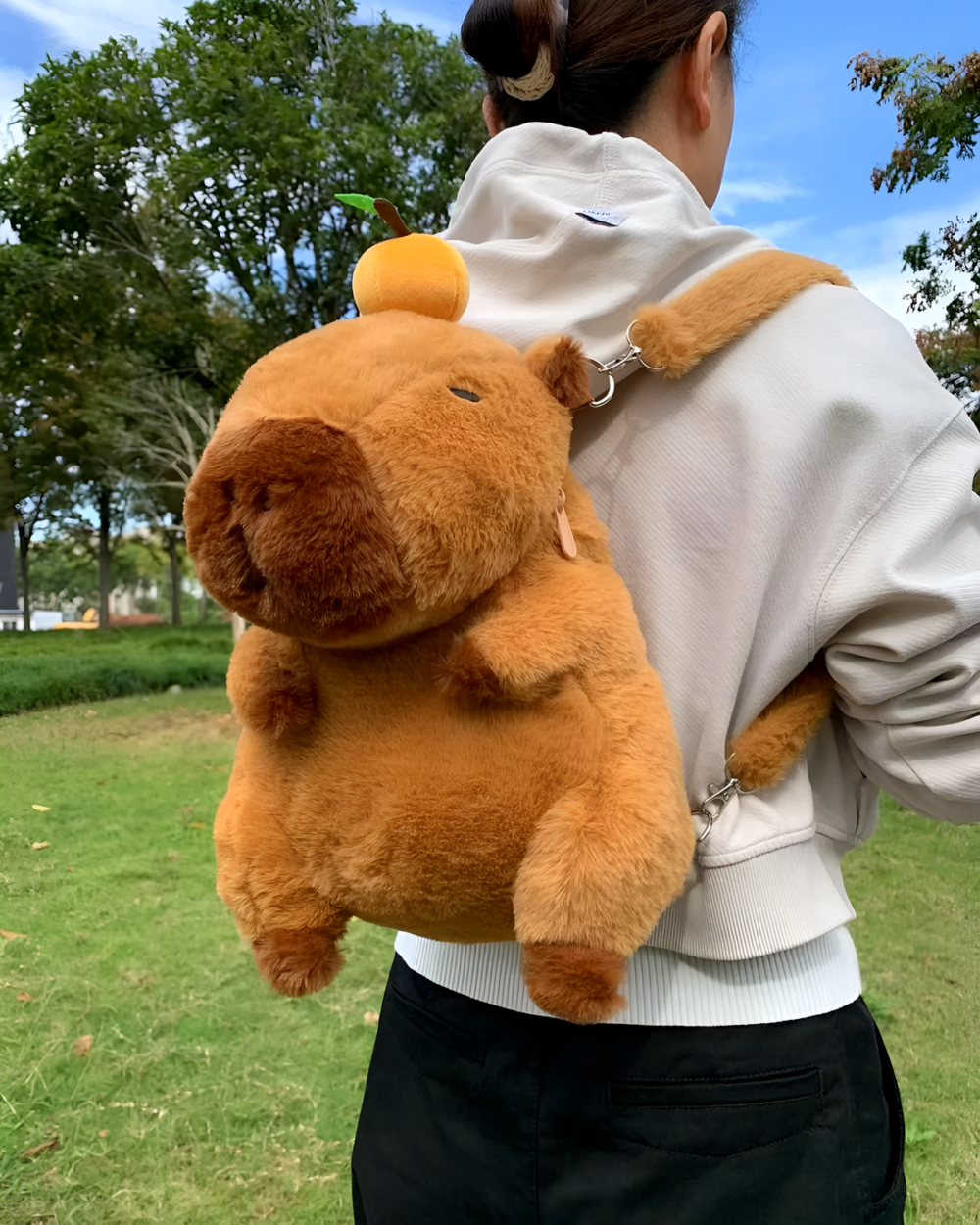 Person wearing a brown Capybara Plushie backpack outdoors. The plush backpack features a realistic capybara design.