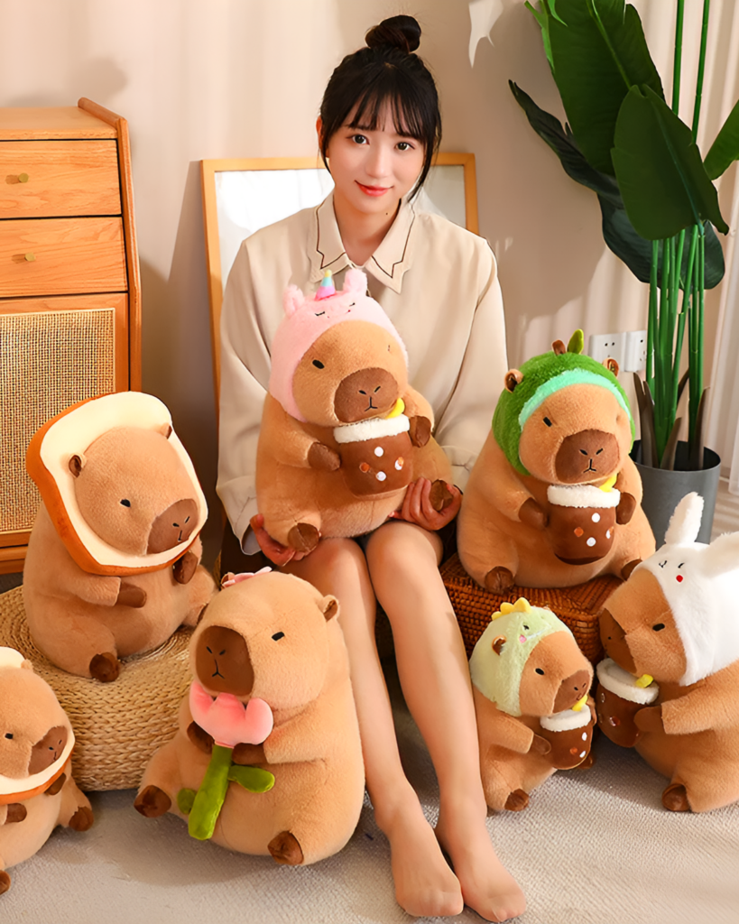 Woman holding assorted capybara plushie toys, including bread and dinosaur designs from the Nature Explorer Edition.