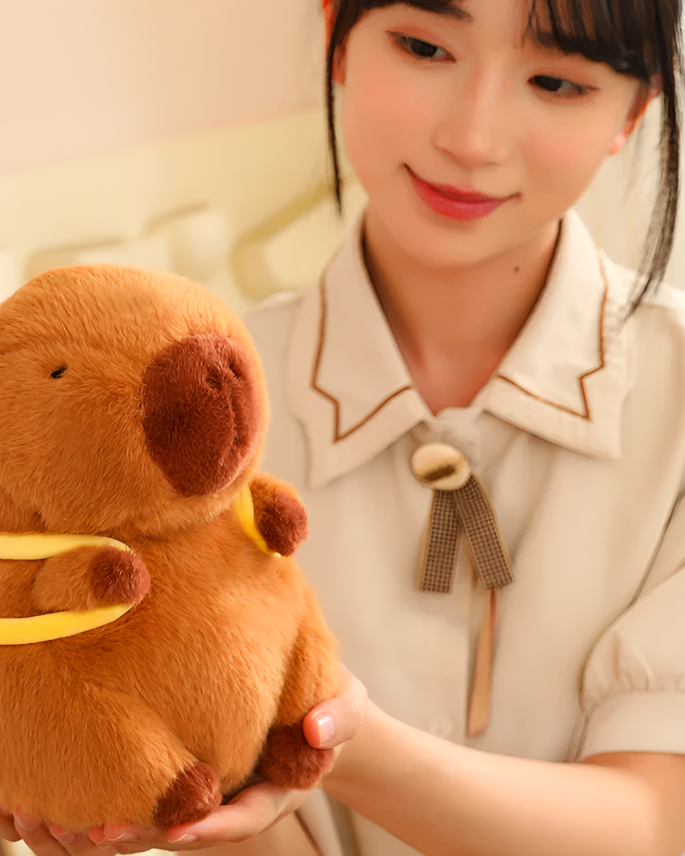 Woman holding a brown capybara plushie from the Nature Explorer Edition. Soft, cuddly animal toy.