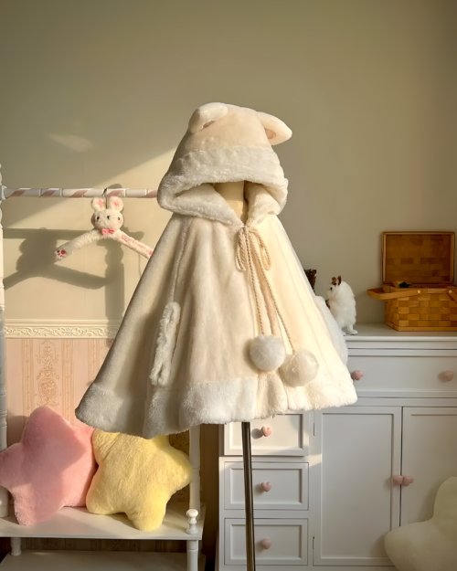 Cream colored Cat Eared Winter Cloak on a dress form, featuring a fluffy hood and tie closures.
