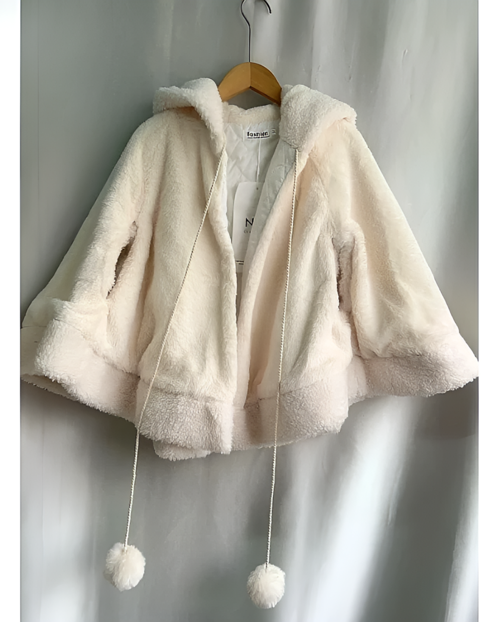 Cream-colored Cat Eared Winter Cloak with hood and tie details. Features a plush, textured surface.