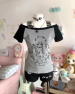 Cat Girl Nurse T-Shirt displayed with accessories and plush toys.